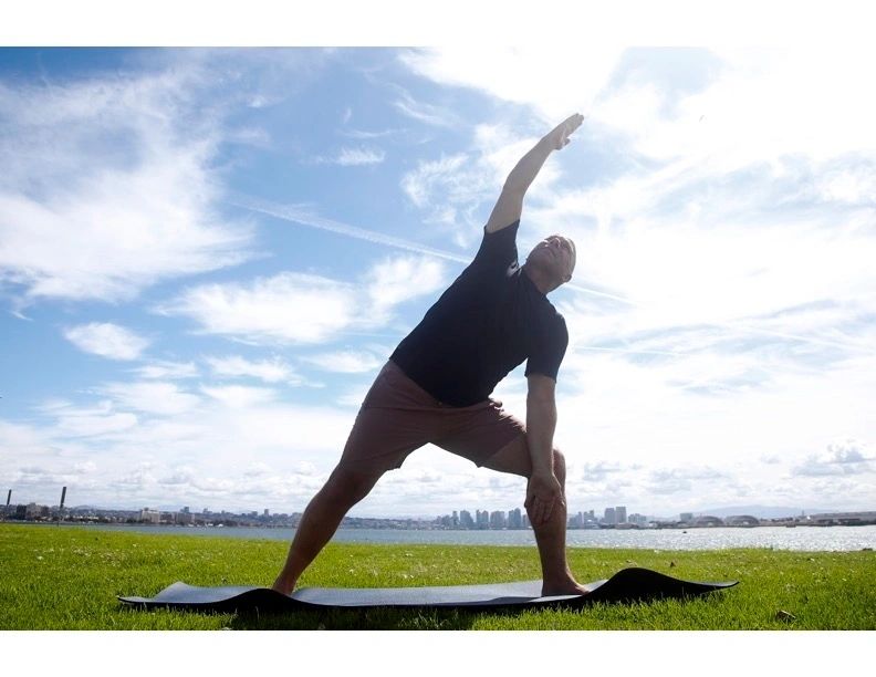 Yoga pose by the waterfront with city skyline